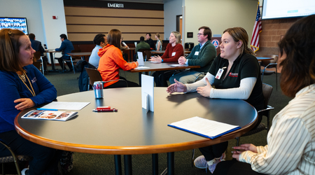 students and employers networking at mock and mingle event sitting around tables